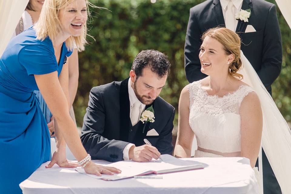 Bride and groom signing the marriage register with Nicole Webster