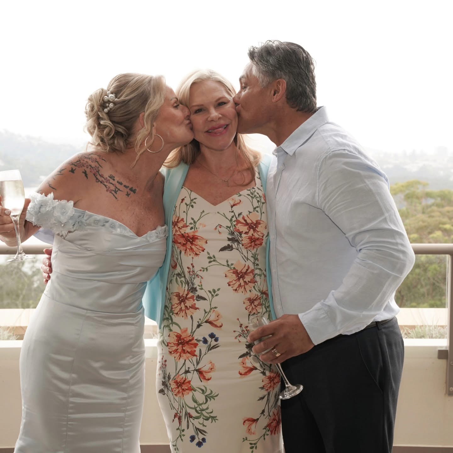 Newlywed couple kissing celebrant Nicole Webster on the cheeks after their ceremony